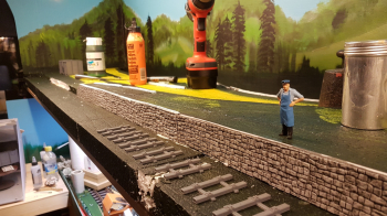 Started building the background team track a few days ago. Glued on first stone wall against the platform this morning. Further away there will be an ore loading ramp for the ore wagons. For this the first sleepers looked a bit to much up-scaled peco....